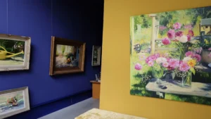 Verlichte expositieruimte met schilderijen aan de muur